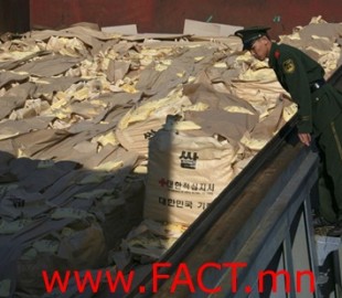 A Chinese frontier policeman checks sacks of rice from South Korea, which will be sent to North Korea, at Dandong port,