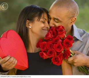 African American man giving Valentine's Day gifts to wife