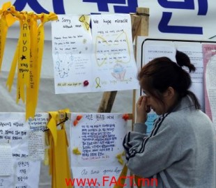 A mother whose teenage child was onboard the capsized Sewol ferry and is missing, cries as she reads messages dedicated to the missing and dead passengers on the ship at a port in Jindo
