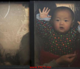 A baby looks through the window of a vehicle stranded on a highway between Beijing and Hebei province, China, that is closed due to smog on an extremely polluted day